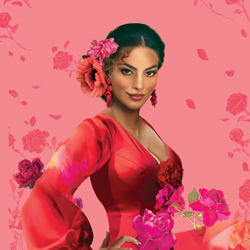 Woman in a vibrant red dress with floral decorations in their hair, standing against a pink background with scattered flowers